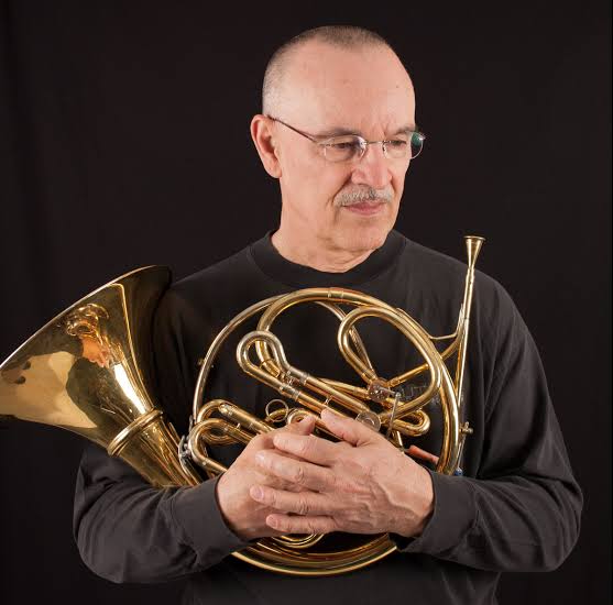 John Clark posing with his horn hugging in front